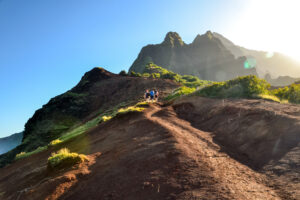 Group of young hikers at Kalalau Valley near Kalalau Beach at Na Pali Coast on the Island of Kauai, Hawaii. The only way to have this unique view from below is to hike the 11 mile long Kalalau Trail.